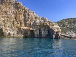 a rocky cliff in the ocean photo