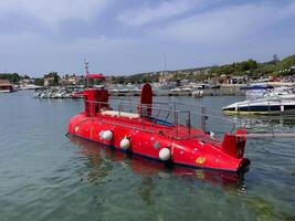 a red submarine in the water photo