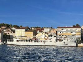 un barco es atracado en el agua cerca un pueblo foto