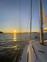 a sailboat is sailing at sunset photo