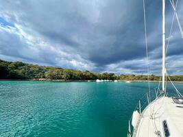 a sailboat on the water with a stormy sky photo