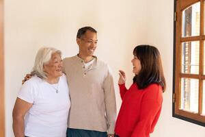 Asian mother talking with her adult children standing in the living room. photo