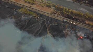 Aerial view of big smoke clouds and fire on the field. Close up view of wildfire, spreading flames of forest fire video