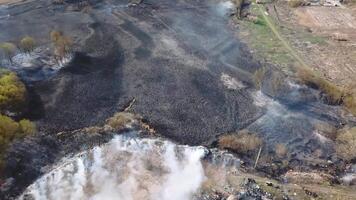 Aerial drone flight over burning hill side with thick white smoke blown off frame . Natural disaster due to extreme heat and climate change video