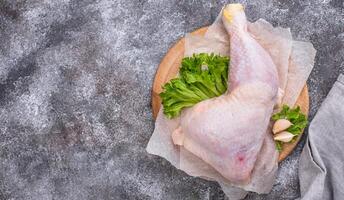 Raw chicken leg on cutting board photo