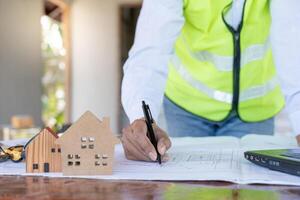 inspector o ingeniero es inspeccionando construcción y calidad garantía nuevo casa utilizando un azul impresión. ingeniero o arquitectos o contactor trabajo a construir el casa antes de entrega eso terminado a el dueño de casa foto