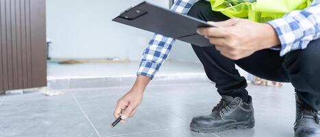 el inspector o ingeniero está inspeccionando la construcción y el aseguramiento de la calidad de la nueva casa usando una lista de verificación. ingenieros o arquitectos o contratistas trabajan para construir la casa antes de entregársela al propietario foto