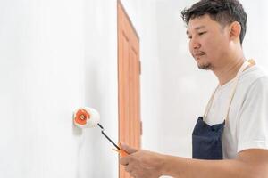 painter man, brush in hand for products to restore and paint the wall, indoor the building site of a house, wall during painting, renovation, painting, contractor, Architect, construction worker photo