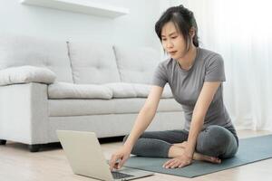 Slim woman practicing yoga on room at condo or home. Asian woman doing exercises in morning. balance, meditation, relaxation, calm, good health, happy, relax, healthy lifestyle, diet, slim photo