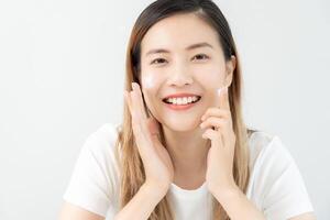 Beautiful Asian woman smile use cream for good skin. face of a healthy woman apply cream and makeup. Advertisement for skin cream, anti-wrinkle, baby face, whitening, moisturizer, tighten pores serum photo