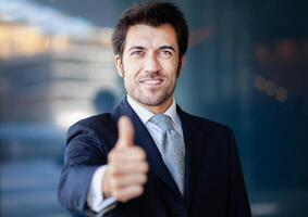 Handsome business man outdoor giving thumbs up photo