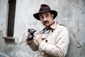 Detective taking pics in a sity slum with his vintage camera photo