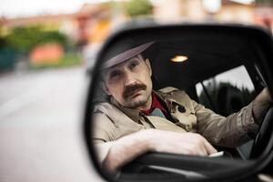 Detective in his car reflected in a mirror while stalking photo