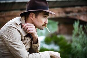 Vintage detective smoking a sigarette and looking depressed photo