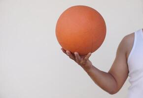 Close up man holds orange basketball. Concept, sport equipment. Play basketball for exercise or play for competition. Exercise for health. Healthy lifestyle. Workout makes strong of body. photo