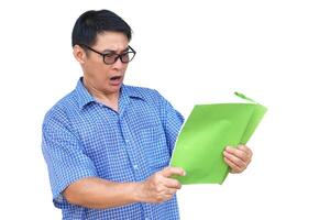 Asian man wear blue shirt, eyeglasses, holds book to read, isolated on white background. Concept , reading for knowledge or pleasure. Hobby and relax time. Face expression with surprised. photo