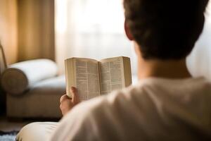 ai generado espalda ver de hombre leyendo santo Biblia libro. atención es en el libro foto