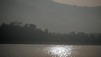 Sunlight reflects beautifully on the water surface, Water surface with light reflections and gentle waves, Serene water with a sun reflection, Reflection of sunset light on water surface, sparkling video