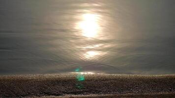 astratto sfocatura leggero su mare e oceano, chiaro acqua, acqua superficie con leggero riflessi e dolce onde, sereno acqua con un' sole riflessione, riflessione di tramonto leggero su il acqua superficie, scintillante video