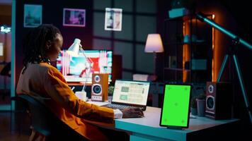 African american business student looking at isolated greenscreen, examining academic software spreadsheet to learn about tax services. Girl using tablet with blank copyspace layout. Camera B. video