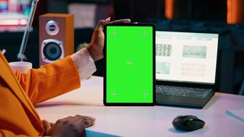 afrikansk amerikan flicka innehav läsplatta med grönskärm layout, ledande data analys för finansiell eller ekonomi kurser. studerande användningar isolerat attrapp visa på enhet, arbete från Hem. kamera a. video