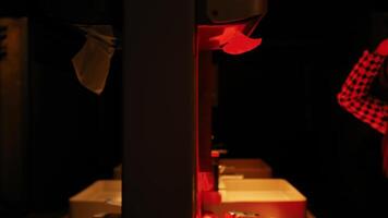 Person washing hands in a dimly lit bathroom with red lighting. video