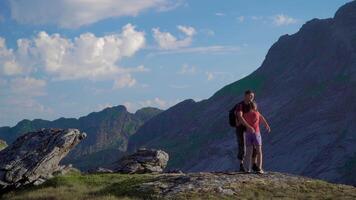 père et fille sont en voyageant dans le montagnes. elles ou ils sont content et prendre plaisir le magnifique la nature de le lofoten îles. Norvège. 4k video