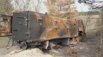 Burnt and destroyed Russian armored military truck for transporting soldiers. The result of the battle between Russian troops and Ukrainian troops near Kyiv. Russian aggression in Ukraine. video