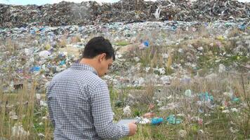 Garbage dump inspector records pollution level on city dump. Ecology pollution concept video