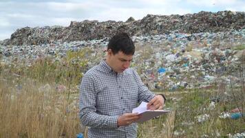 Garbage dump inspector records pollution level. Ecology pollution concept video