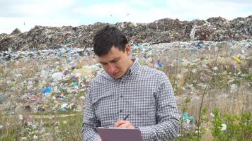 Garbage dump inspector records pollution level on city dump. Ecology pollution concept video