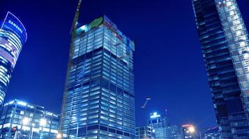 Pattern of office buildings windows illuminated at night. Glass architecture ,corporate building at night - business concept. Blue graphic filter. photo