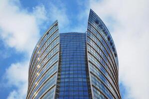 Structural glass wall reflecting blue sky. Abstract modern architecture fragment photo