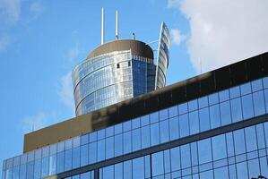 Structural glass wall reflecting blue sky. Abstract modern architecture fragment photo