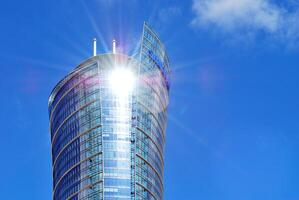 Glass building with transparent facade of the building and blue sky. Structural glass wall reflecting blue sky. Abstract modern architecture fragment. Contemporary architectural background. photo