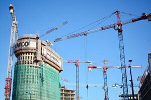 High rise building under construction. Installation of glass facade panels on a reinforced concrete structure. photo