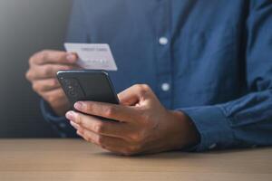 Businessman using mobile phone and holding credit card. Digital information technology and cyber security concept. photo