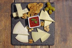 Plate with assortment of cheeses on the wooden table photo