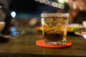 Glasses of ice whiskey on wood table. photo