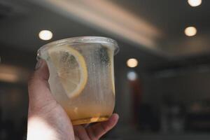 Cool lemon soda with lemon fruit in hand. photo