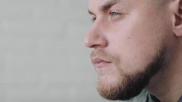 Contemplative Man Close-up, Close-up side view of a thoughtful man with a neutral background. video