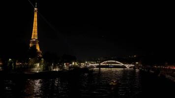 illuminé Eiffel la tour à nuit par Seine rivière, nocturne éclat de Eiffel la tour, reflets sur Seine rivière, iconique nuit vue video