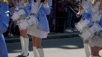 calle actuación de festivo marzo de bateristas muchachas en azul disfraces en ciudad calle. de cerca de hembra manos bateristas son golpes en el tambor de su palos video