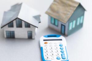 Toy house and calculator on table close-up photo