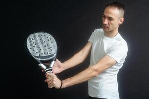 Padel Tennis Player with Racket in Hands. Paddle tennis, on a black background. photo