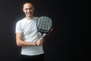 padel tenis jugador con raqueta en mano. paleta tenis, en un negro antecedentes. foto