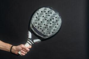 Paddle tennis player ready for serve on gray background photo