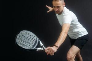 Padel Tennis Player with Racket in Hands. Paddle tennis, on a black background. photo