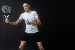 Padel Tennis Player with Racket in Hand. Paddle tennis, on a black background. photo