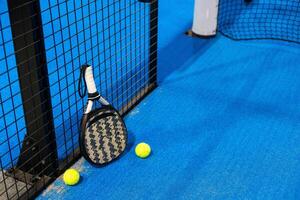 Paddle tennis racket, ball and net on the court photo